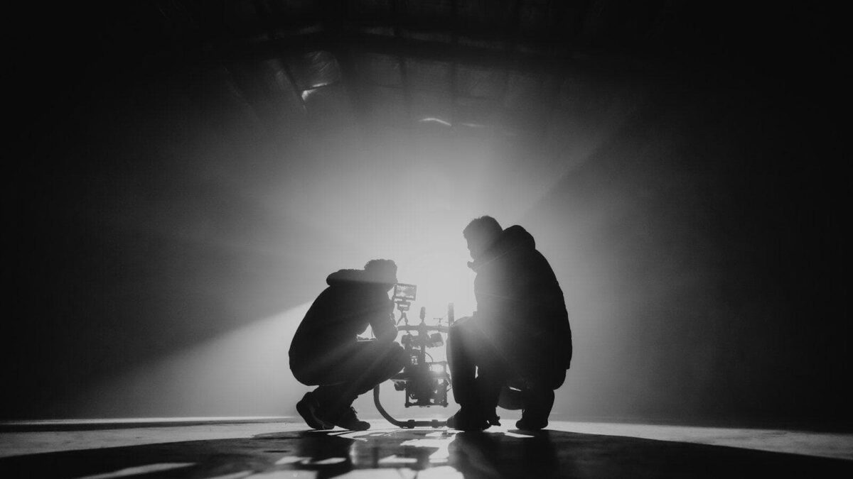 grayscale photography of two crouching men