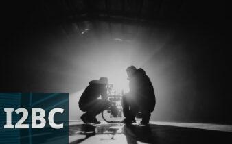 grayscale photography of two crouching men
