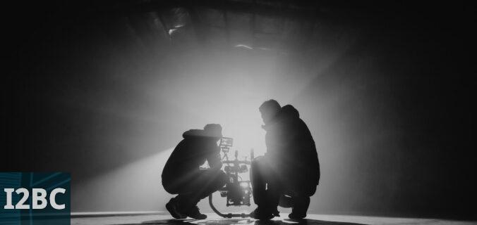 grayscale photography of two crouching men